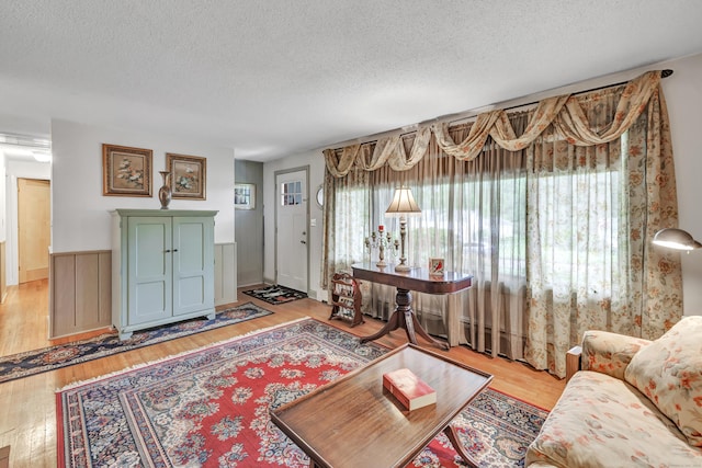 26 Williams Rd, Cheshire, CT 06410 - living room featuring a textured ceiling, wood finished floors, and a wainscoted wall