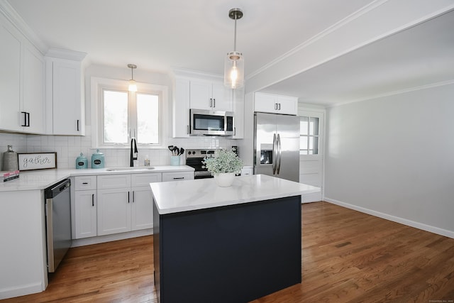5 Roberge Rd, Bristol, CT 06010 - kitchen featuring appliances with stainless steel finishes, a sink, tasteful backsplash, a kitchen island, and ornamental molding
