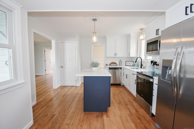 5 Roberge Rd, Bristol, CT 06010 - kitchen with appliances with stainless steel finishes, a sink, a center island, and light wood-style flooring