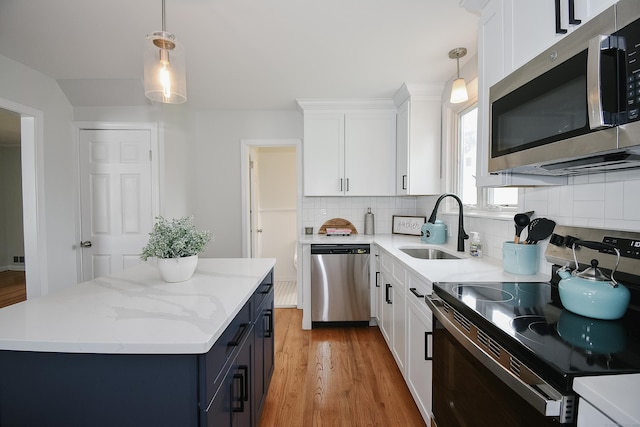 5 Roberge Rd, Bristol, CT 06010 - kitchen featuring stainless steel appliances, a sink, light wood-style flooring, and white cabinetry
