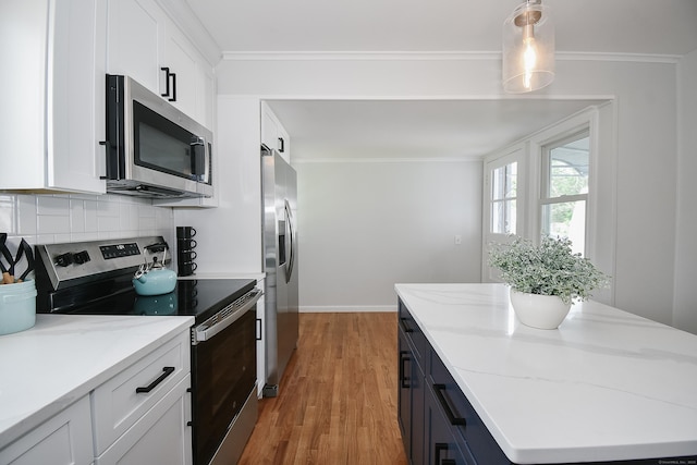 5 Roberge Rd, Bristol, CT 06010 - kitchen featuring appliances with stainless steel finishes, white cabinetry, decorative backsplash, light wood-style floors, and crown molding
