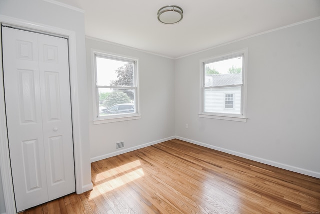 5 Roberge Rd, Bristol, CT 06010 - unfurnished bedroom with ornamental molding, baseboards, light wood-style floors, and a closet