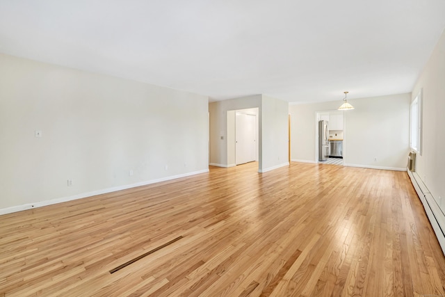 42 N Lake Dr Apt C2, Hamden, CT 06517 - unfurnished living room featuring a baseboard heating unit, light wood finished floors, and baseboards