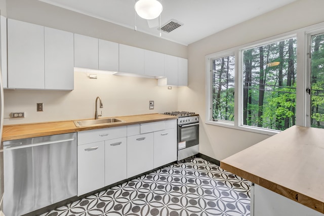 42 N Lake Dr Apt C2, Hamden, CT 06517 - kitchen featuring appliances with stainless steel finishes, a sink, butcher block counters, white cabinets, and baseboards