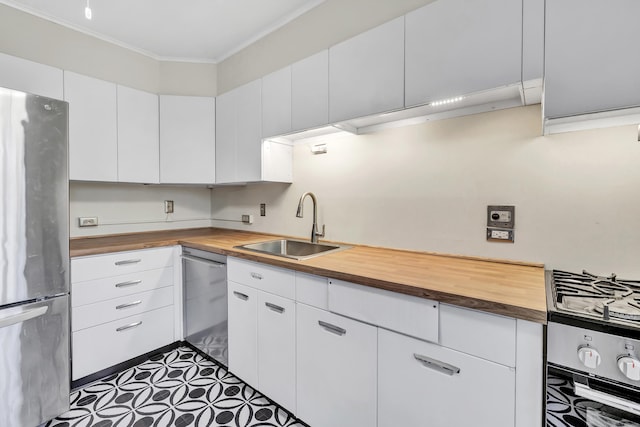42 N Lake Dr Apt C2, Hamden, CT 06517 - kitchen featuring wood counters, appliances with stainless steel finishes, a sink, crown molding, and white cabinetry