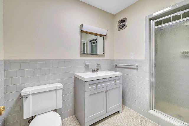 42 N Lake Dr Apt C2, Hamden, CT 06517 - bathroom with tile walls, a stall shower, toilet, vanity, and wainscoting