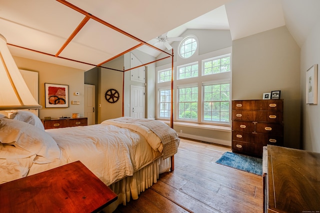 bedroom featuring hardwood / wood-style flooring and high vaulted ceiling