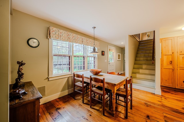 dining space with baseboards, stairs, light wood finished floors, baseboard heating, and recessed lighting