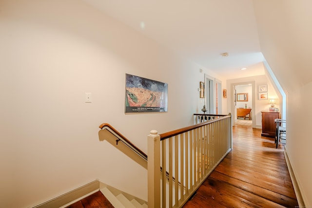 corridor featuring an upstairs landing, hardwood / wood-style floors, and baseboards