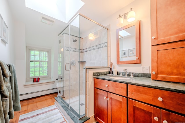 full bathroom featuring a baseboard radiator, wood finished floors, vanity, and a stall shower