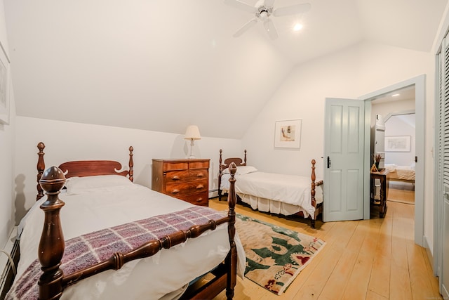 bedroom featuring lofted ceiling, light wood-style flooring, a ceiling fan, and baseboard heating
