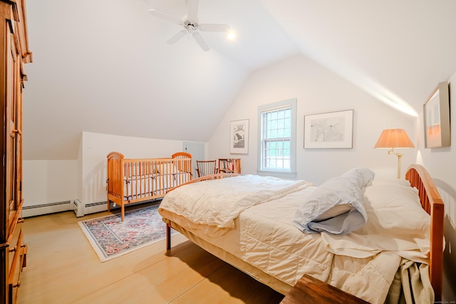 bedroom featuring light wood-type flooring, vaulted ceiling, ceiling fan, and a baseboard heating unit