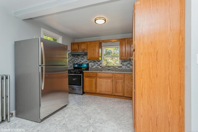 70 Maple St, Meriden, CT 06451 - kitchen featuring appliances with stainless steel finishes, decorative backsplash, radiator heating unit, under cabinet range hood, and brown cabinets