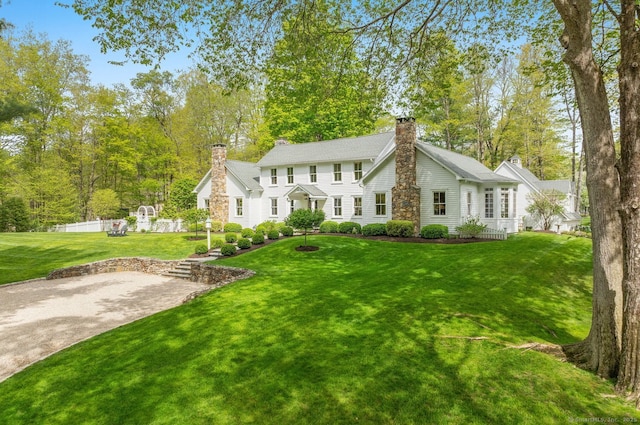 view of front facade featuring a chimney and a front yard