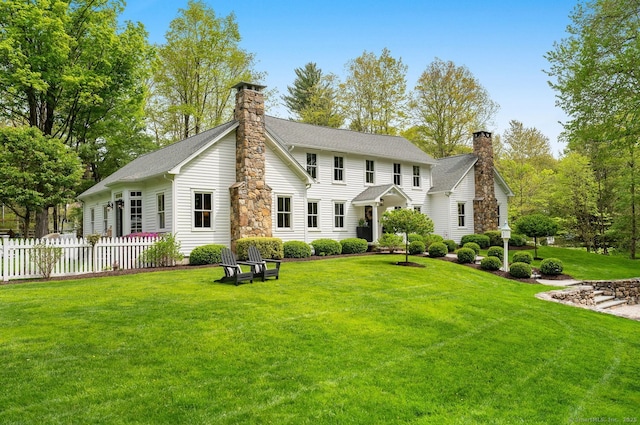 back of property with a chimney and a shingled roof