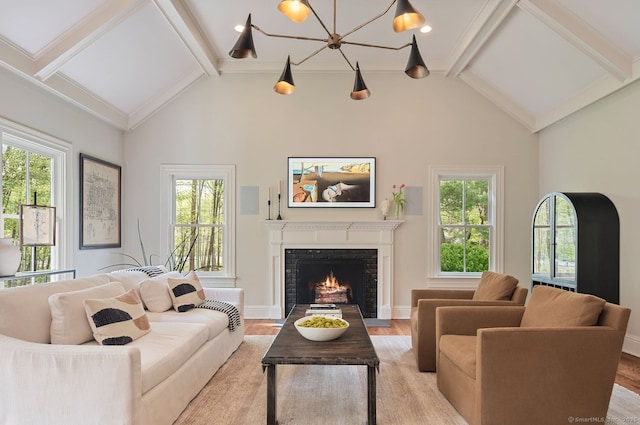 living area with light wood-style flooring, beamed ceiling, plenty of natural light, a fireplace with flush hearth, and high vaulted ceiling