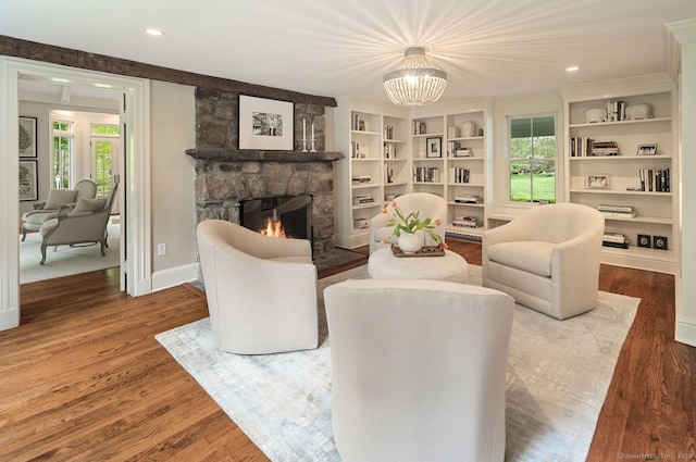 living area featuring a stone fireplace, healthy amount of natural light, a chandelier, wood finished floors, and recessed lighting