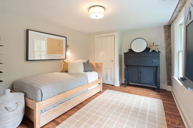 bedroom featuring wood finished floors and baseboards