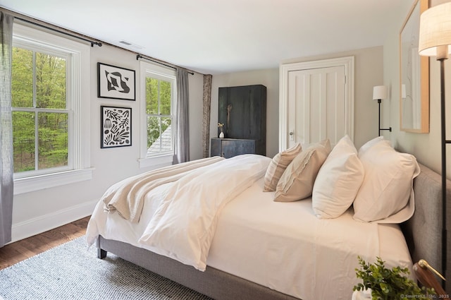 bedroom with wood finished floors and baseboards