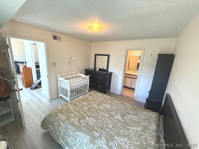 202 Carriage Crossing Ln Unit 202, Middletown, CT 06457 - bedroom featuring a textured ceiling and wood finished floors