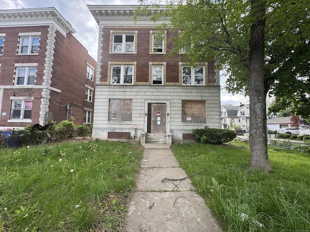 view of front of property with brick siding and a front lawn