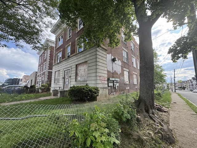view of home's exterior featuring fence and brick siding
