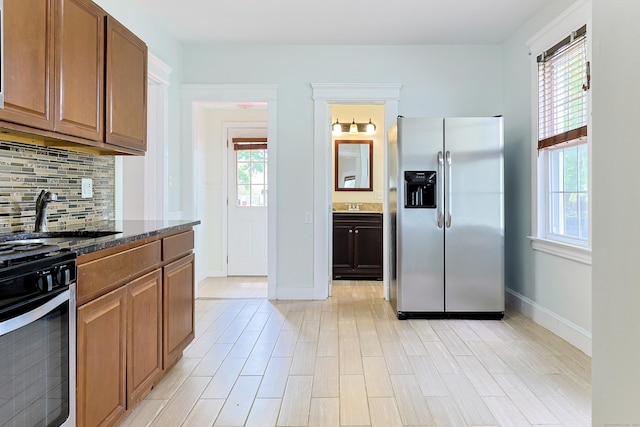262 Blohm St, West Haven, CT 06516 - kitchen with appliances with stainless steel finishes, backsplash, baseboards, a sink, and dark stone counters