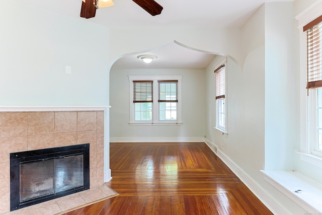 262 Blohm St, West Haven, CT 06516 - unfurnished living room with arched walkways, a tile fireplace, hardwood / wood-style flooring, baseboards, and a ceiling fan