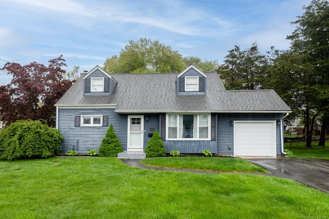 new england style home featuring driveway, a garage, a front yard, and a shingled roof