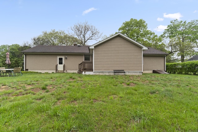 rear view of property featuring a yard