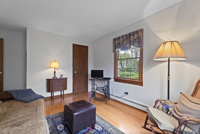 living room featuring a baseboard heating unit and wood finished floors