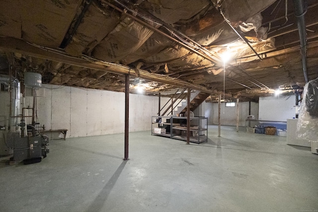 unfinished below grade area featuring stairs and a heating unit