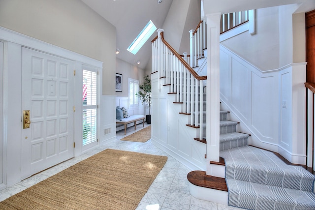 63 Balfour Dr, West Hartford, CT 06117 - entryway featuring a decorative wall, stairway, a wainscoted wall, and high vaulted ceiling