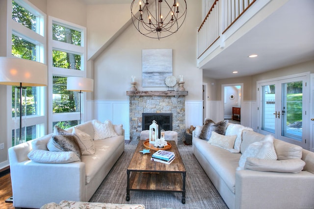 63 Balfour Dr, West Hartford, CT 06117 - living room with a towering ceiling, a chandelier, wood finished floors, wainscoting, and a stone fireplace