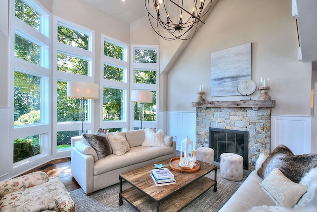 63 Balfour Dr, West Hartford, CT 06117 - living room featuring a high ceiling, plenty of natural light, a chandelier, wainscoting, and a decorative wall