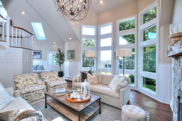 63 Balfour Dr, West Hartford, CT 06117 - living room with a high ceiling, baseboard heating, wood finished floors, a decorative wall, and healthy amount of natural light