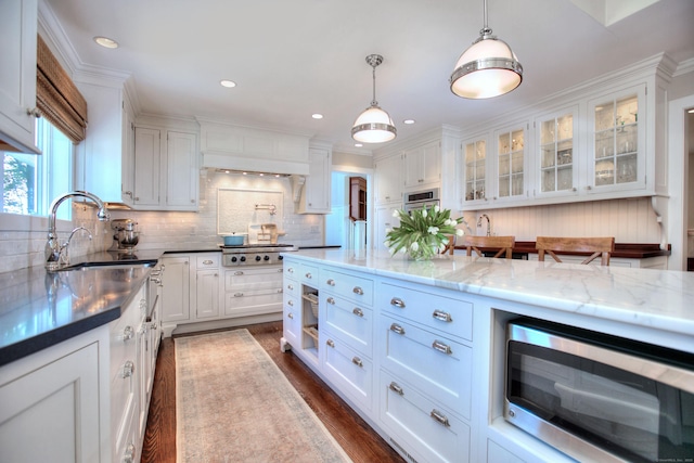 63 Balfour Dr, West Hartford, CT 06117 - kitchen featuring appliances with stainless steel finishes, a sink, white cabinets, dark wood finished floors, and decorative light fixtures
