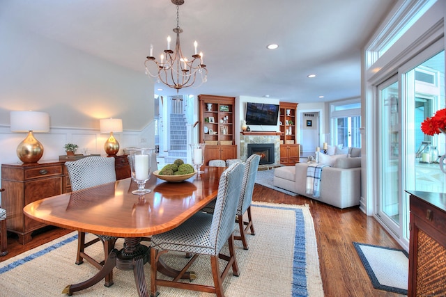 63 Balfour Dr, West Hartford, CT 06117 - dining area with wood finished floors, recessed lighting, a chandelier, a warm lit fireplace, and wainscoting
