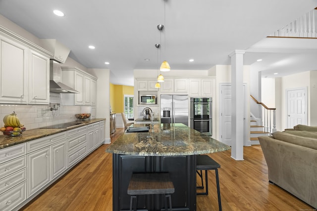 140 Podunk Rd, Guilford, CT 06437 - kitchen with a sink, appliances with stainless steel finishes, wall chimney exhaust hood, wood finished floors, and recessed lighting
