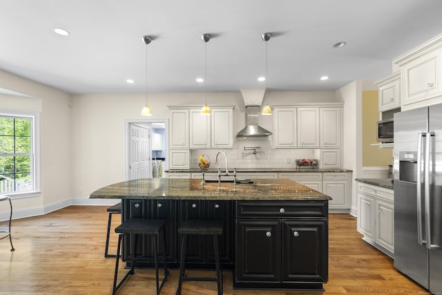 140 Podunk Rd, Guilford, CT 06437 - kitchen with appliances with stainless steel finishes, wall chimney range hood, a sink, decorative backsplash, and light wood-style floors