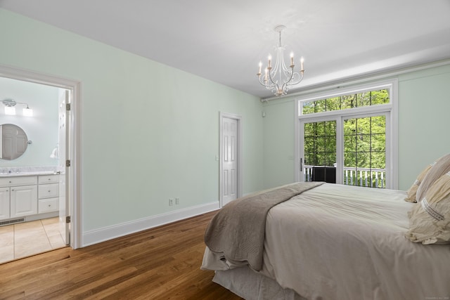 140 Podunk Rd, Guilford, CT 06437 - bedroom featuring a chandelier, light wood-style floors, connected bathroom, and baseboards