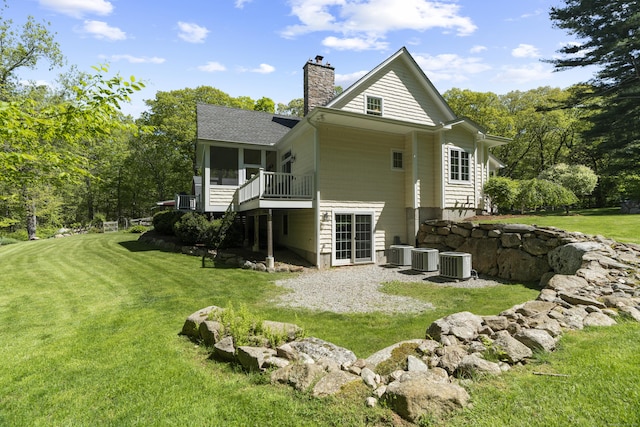 140 Podunk Rd, Guilford, CT 06437 - rear view of property featuring a sunroom, central AC unit, a chimney, and a yard