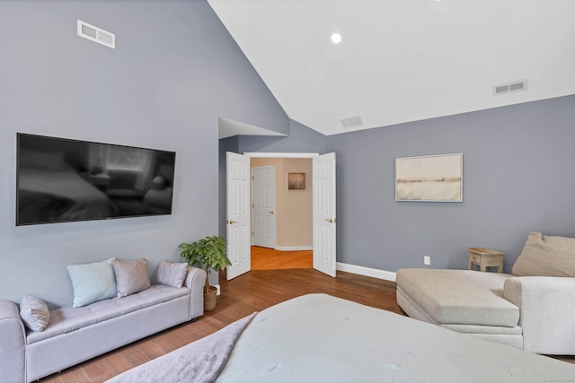 bedroom with baseboards, high vaulted ceiling, and wood finished floors