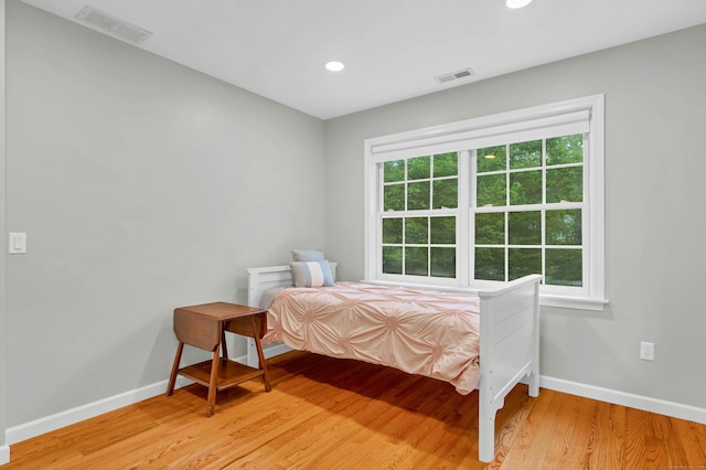 bedroom featuring baseboards, light wood-style flooring, and recessed lighting