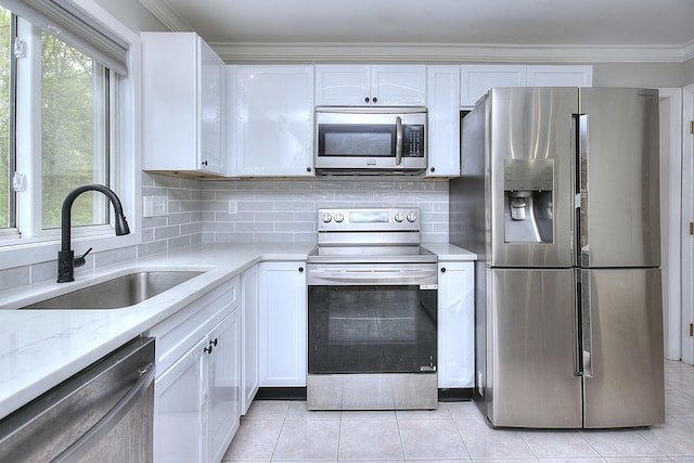 23 Davis Rd, Seymour, CT 06483 - kitchen featuring appliances with stainless steel finishes, white cabinets, light tile patterned flooring, decorative backsplash, and crown molding
