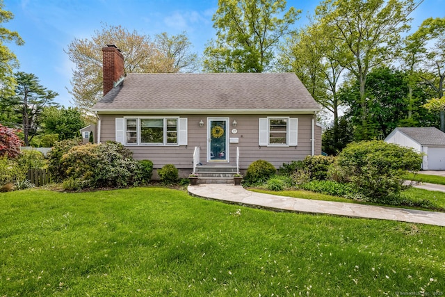 view of front of house featuring a front yard, a chimney, and roof with shingles