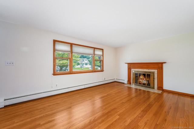 unfurnished living room featuring a baseboard radiator, wood finished floors, and a fireplace with flush hearth