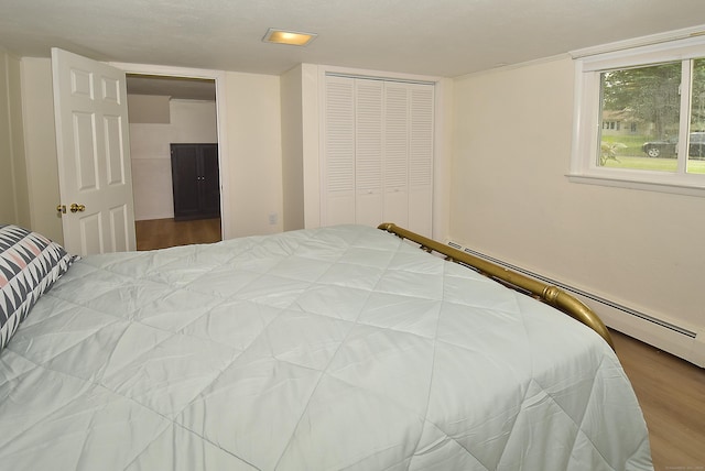 21 Craigmore Rd, Bloomfield, CT 06002 - bedroom featuring wood finished floors, a closet, and a baseboard heating unit