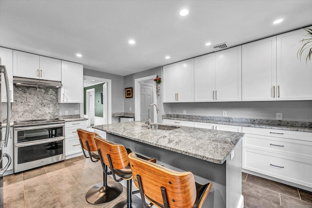 10 Meadowbrook Rd, Hamden, CT 06517 - kitchen with a sink, range with two ovens, recessed lighting, under cabinet range hood, and white cabinets