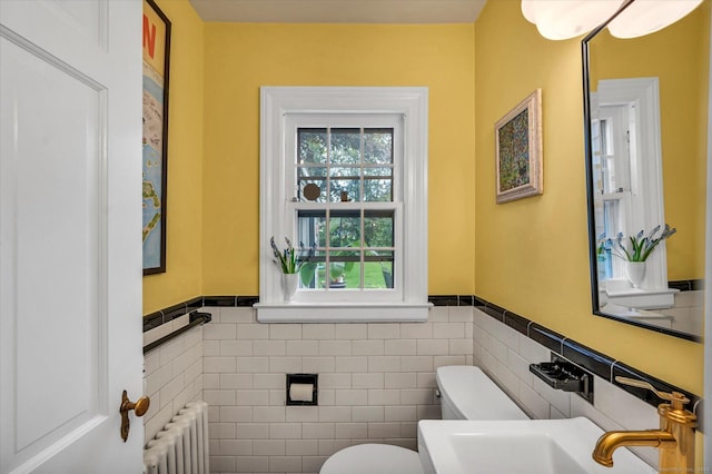 10 Meadowbrook Rd, Hamden, CT 06517 - half bathroom featuring radiator heating unit, toilet, tile walls, and wainscoting